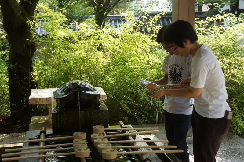 Tourists drinking holy water that has not yet transformedi into sake