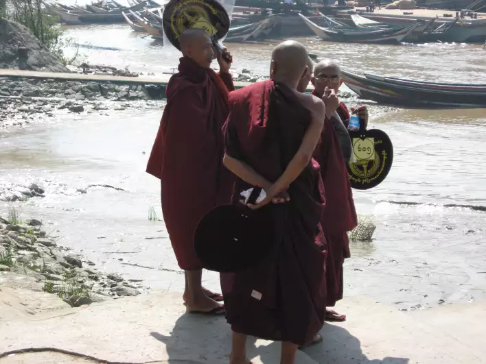 Monks throwing trash and plastic bottles on their way to a river cruise