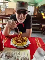 A dude eating ketchup with French fries