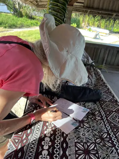 Kiribati writing postcards