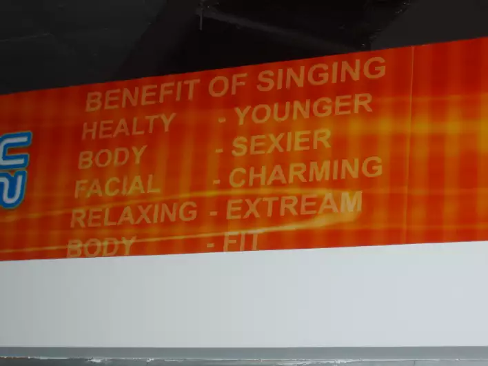 The advertisement promises that youll become younger, sexier and more charming by singing karaoke